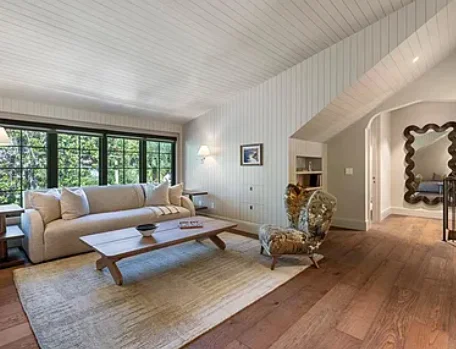 Warm wood flooring in a furnished living room
